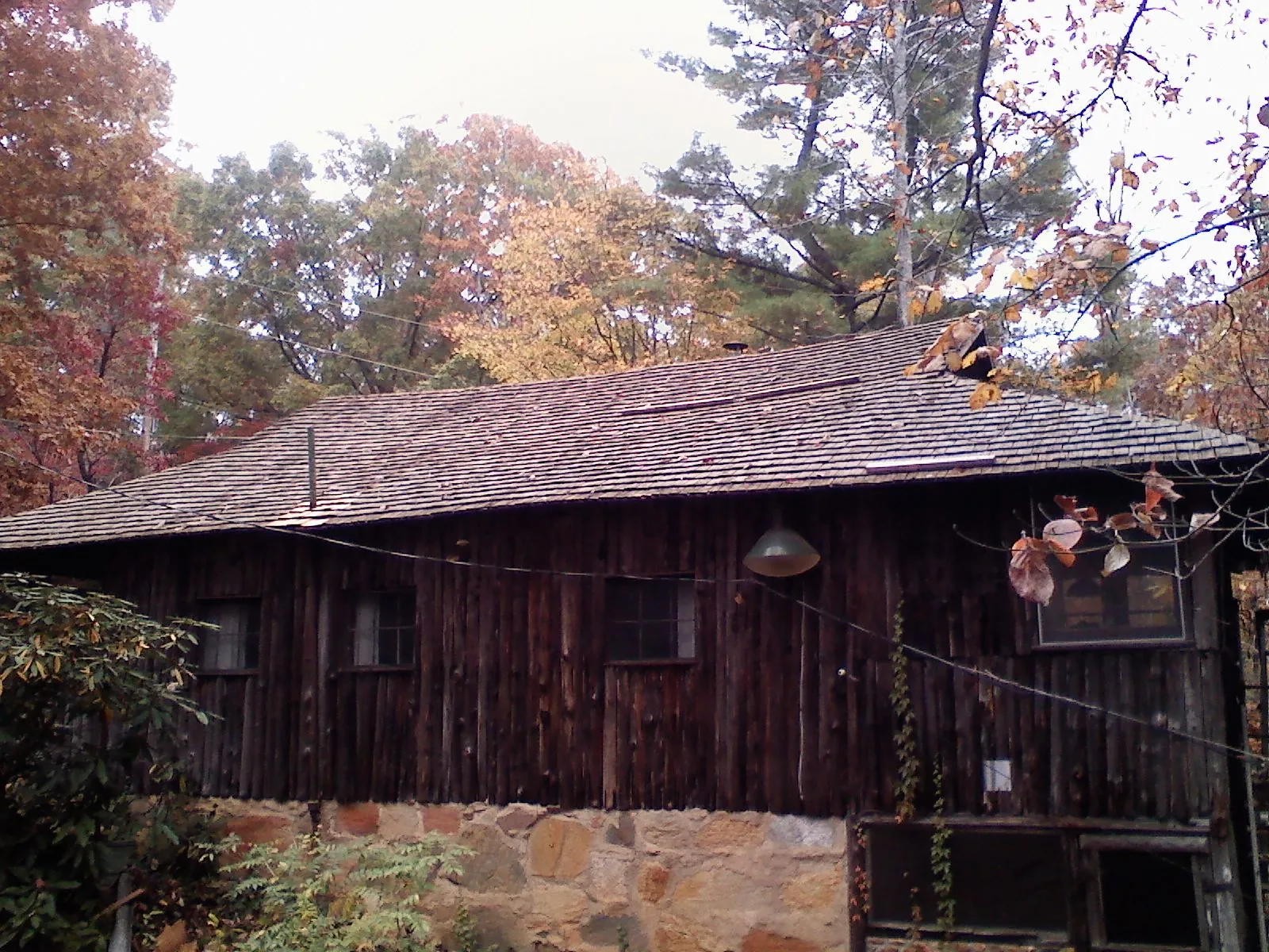 Weathered wood shake roof on a rustic board sided cabin in Mills River