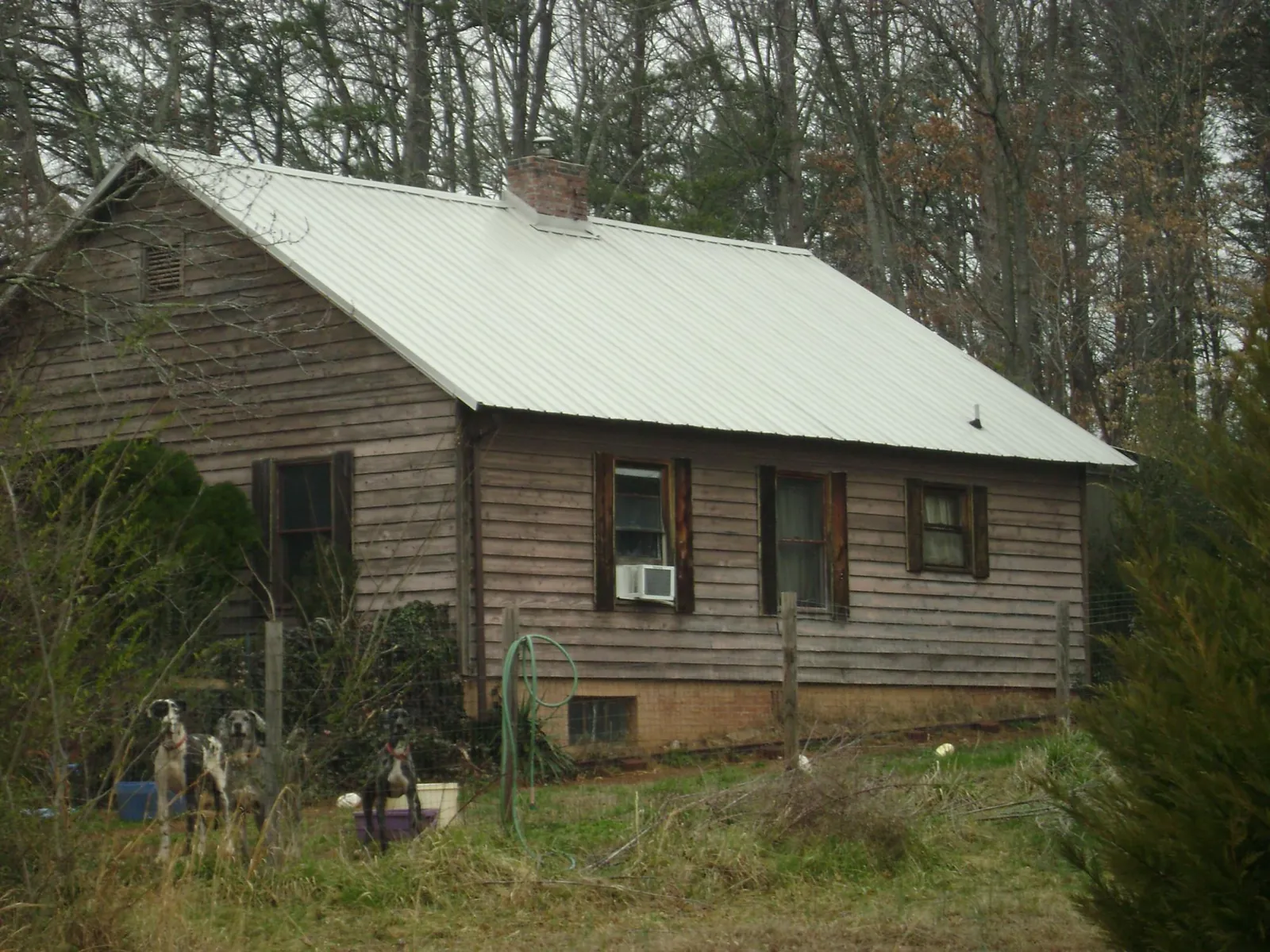White metal roof on an old wood sided farmhouse, from a Metal Roof Installation job in Mills River